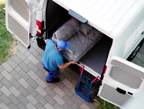 Movers carrying a sofa from a home to a moving truck in Perth, WA
